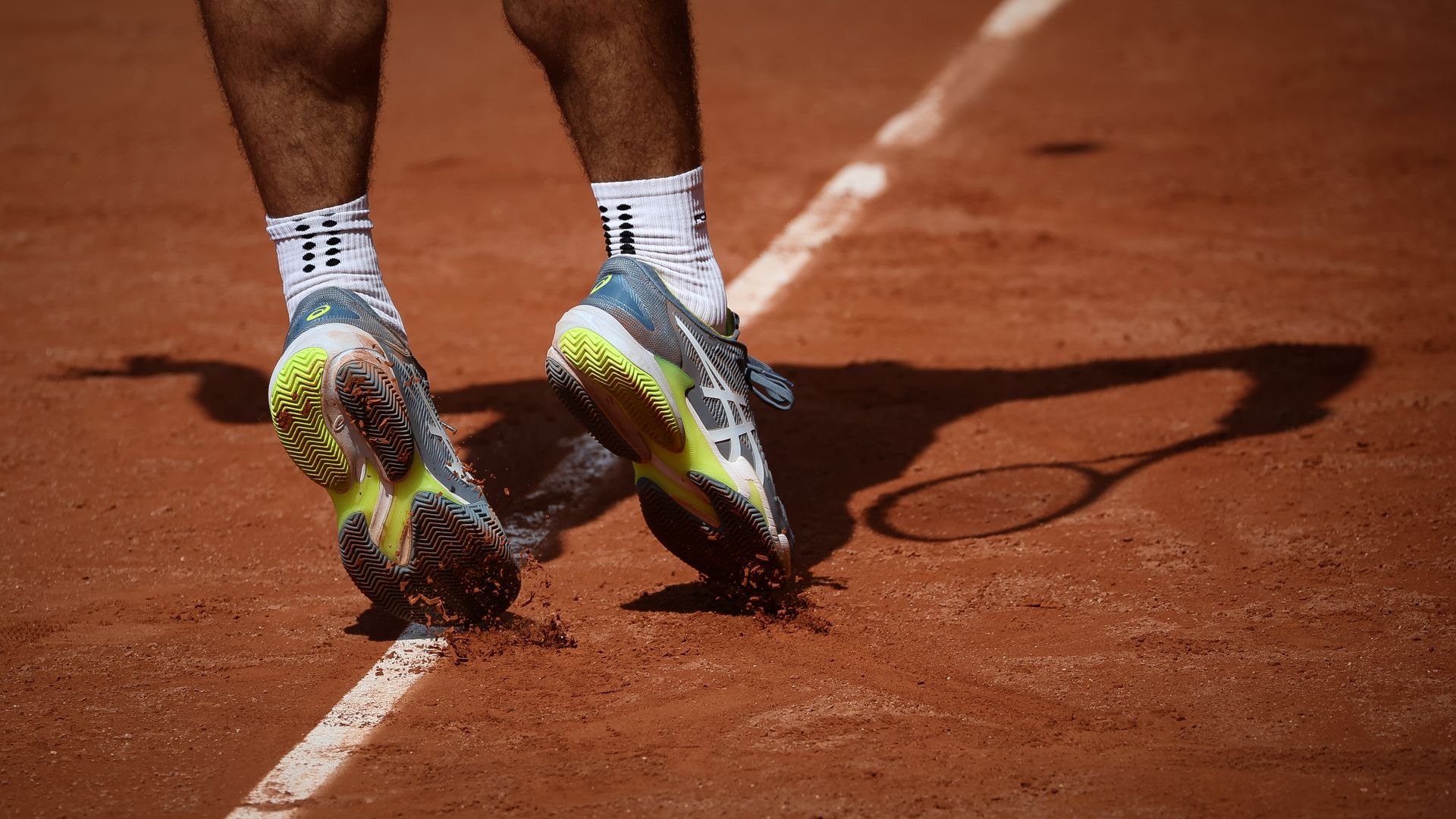 Tennis player sliding on a clay court