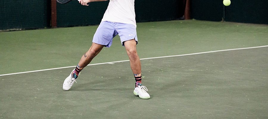Player split-stepping in white K-Swiss Ultrashot 3 shoes with the ball in frame